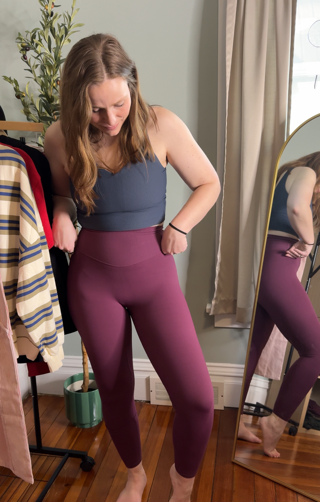 Woman trying on purple leggings in a mirror