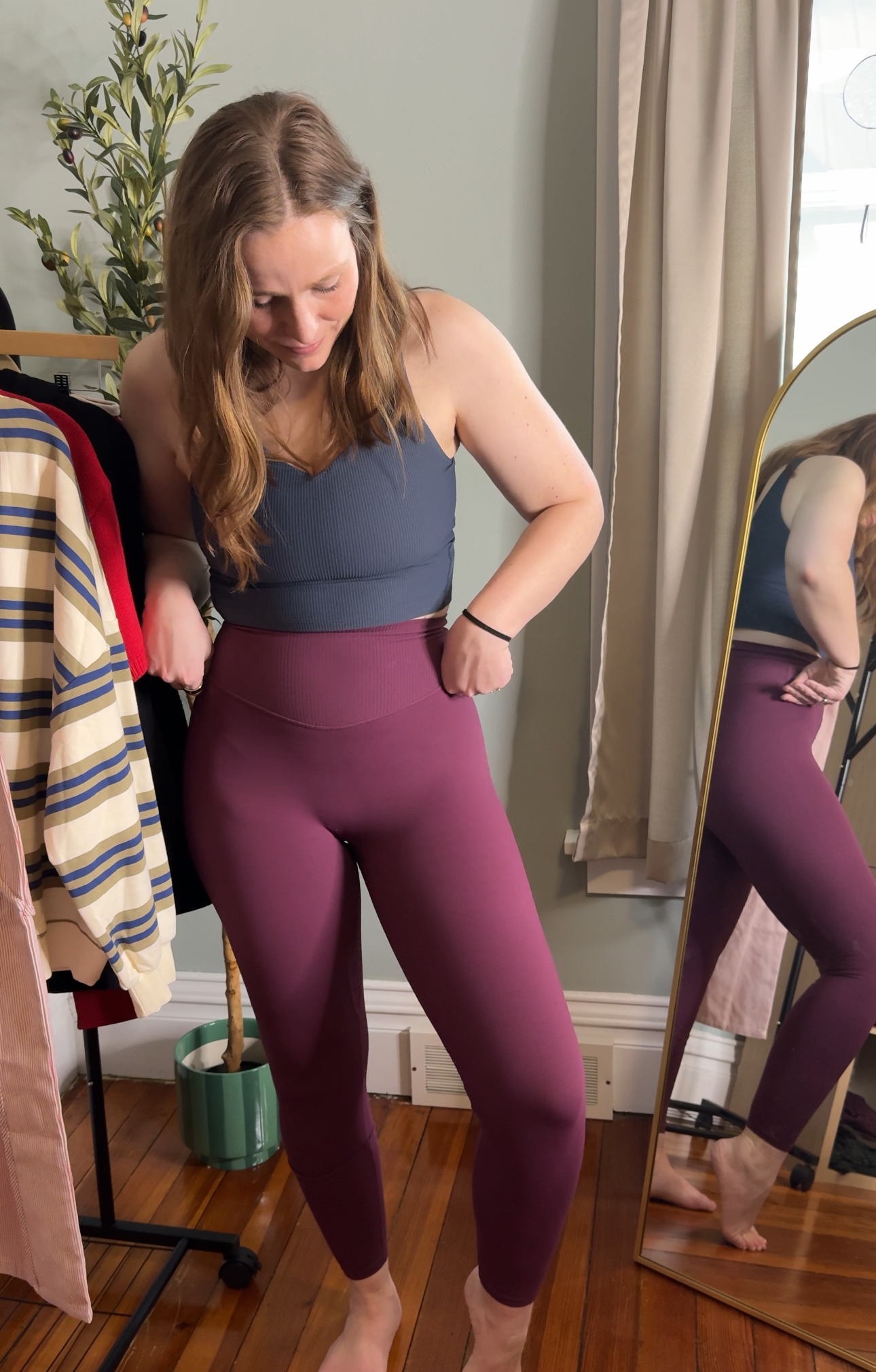 Woman trying on purple leggings in a mirror